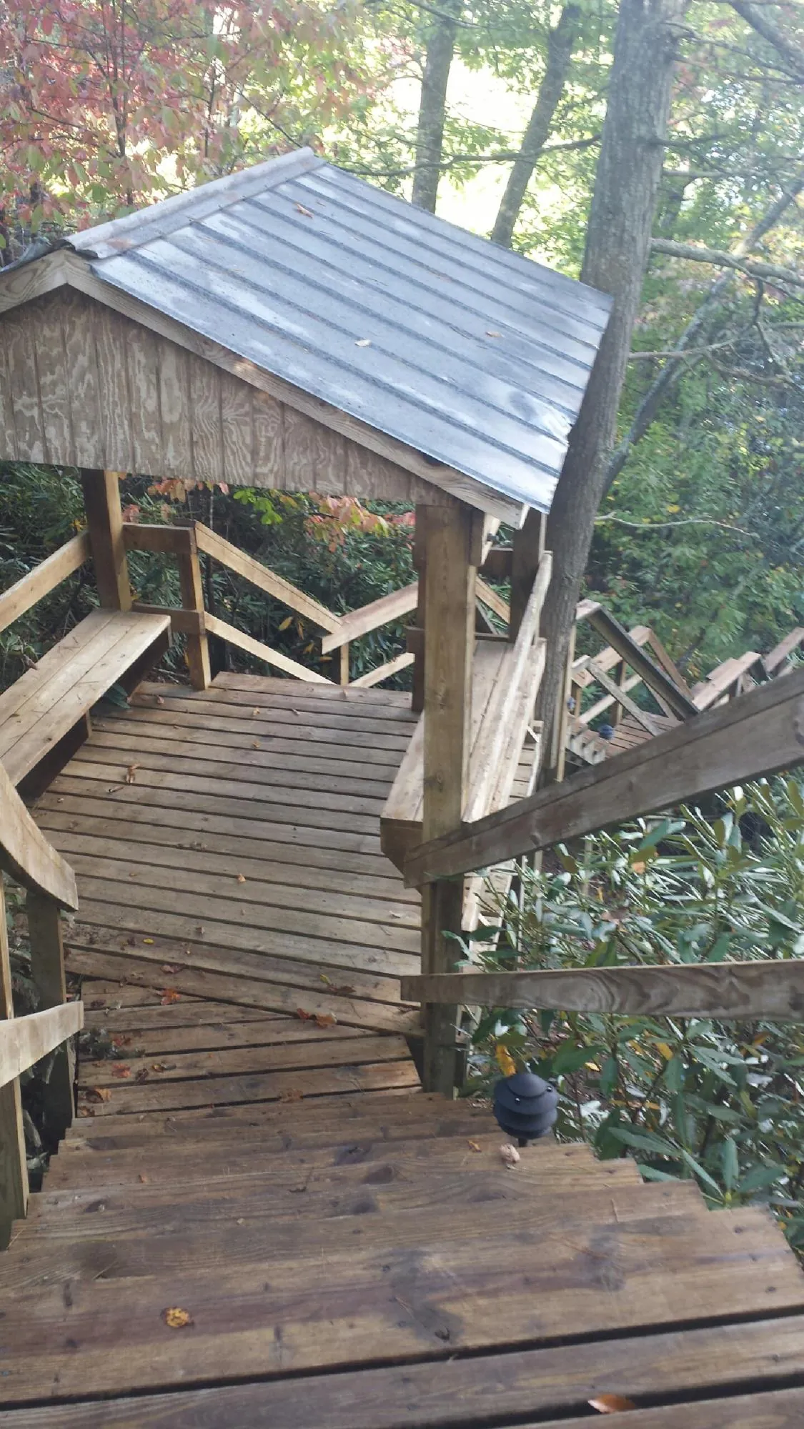 Metal roofed shelter over wooden steps on a wooded walkway — Skylight Repair & Installation work by our crew in Austin